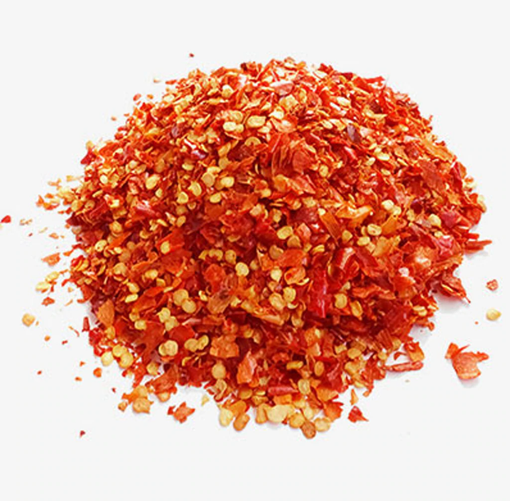 Red chilli flakes in a wooden bowl with whole dried chillies